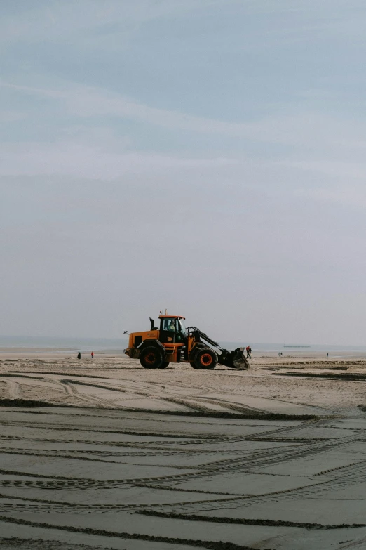 a tractor sitting on top of a sandy beach, a picture, unsplash, plasticien, people at work, gray wasteland, clearing. full shot, bay area