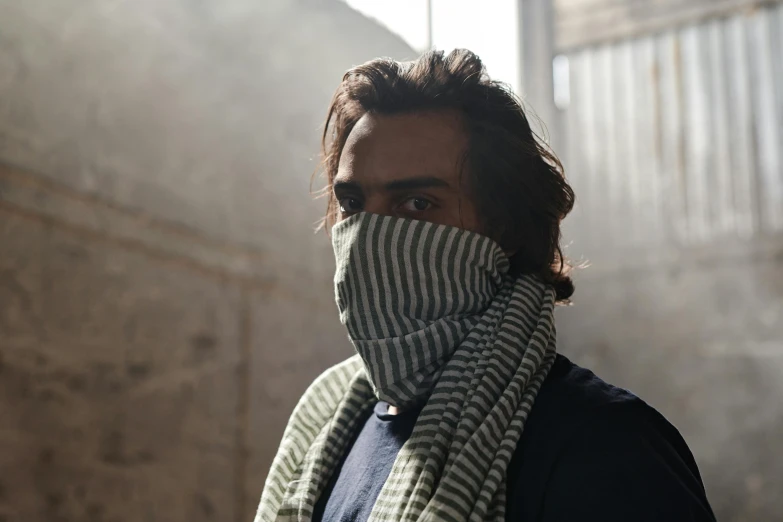 a close up of a person wearing a scarf, by Helen Stevenson, unsplash, real life photo of a syrian man, stood in a factory, sage smoke, striped