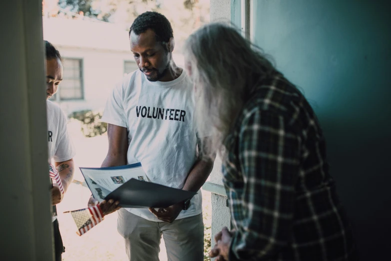 a group of people standing in front of a door, writing on a clipboard, skilled homeless, profile image, a black man with long curly hair