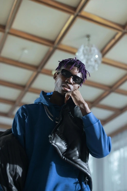 a man with purple hair talking on a cell phone, an album cover, trending on pexels, ( ( dark skin ) ), casual pose, schools, wearing oakley sunglasses