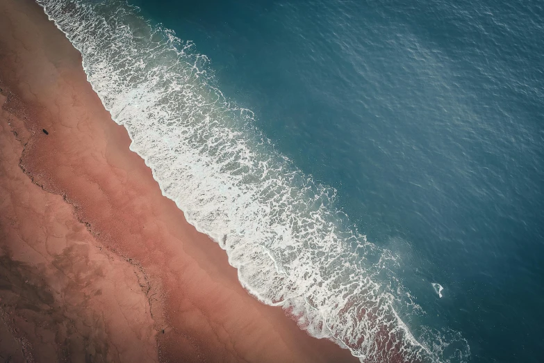 a large body of water next to a sandy beach, unsplash contest winner, hurufiyya, bloody ocean, air shot, red brown and white color scheme, blue ocean