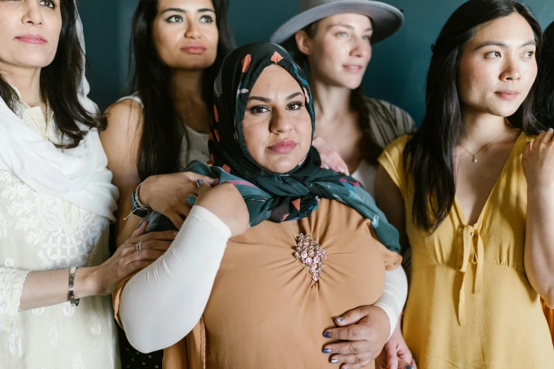 a group of women standing next to each other, trending on pexels, hurufiyya, arm around her neck, head scarf, sie boob, manuka