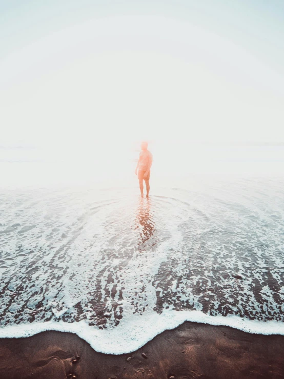 a person standing in the water at the beach, faded out colors, the ego separates, lots of light, leaving a room