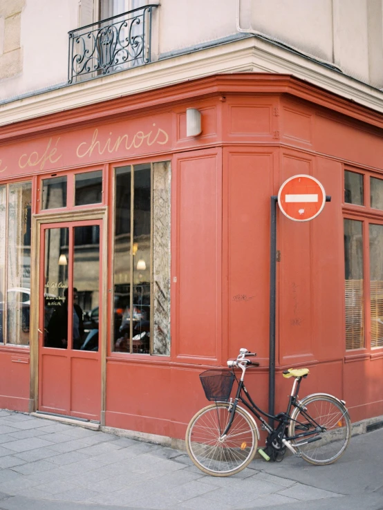 a bicycle parked in front of a red building, a photo, trending on unsplash, paris school, chinatown bar, cronenberg bookshop, a quaint, 🚿🗝📝