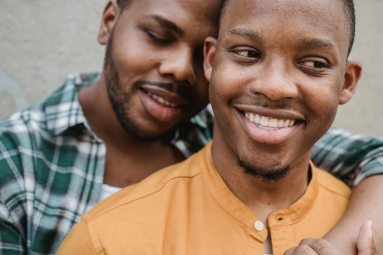 a couple of men standing next to each other, trending on pexels, light brown skin, embracing, gay, ad image