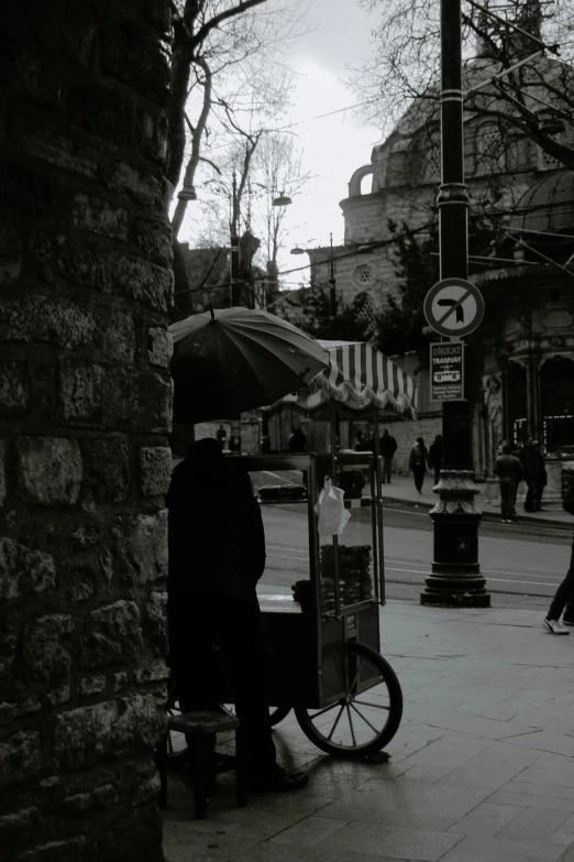 a black and white photo of a person with an umbrella, a black and white photo, by Niyazi Selimoglu, street art, cart, instagram story, old city, color picture