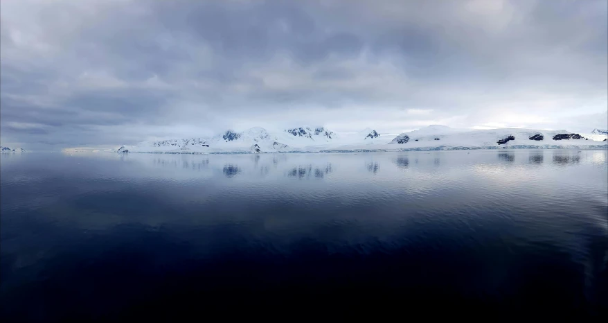 a large body of water with mountains in the background, by Peter Churcher, pexels contest winner, hurufiyya, antarctic mountains, serene overcast atmosphere, photo on iphone, ultrawide cinematic