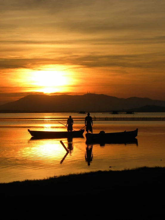 a couple of boats sitting on top of a lake, a picture, inspired by Fernando Amorsolo, pexels contest winner, sunset beach, thumbnail, hunting, walking down