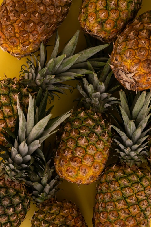 a bunch of pineapples on a yellow surface, slide show, uncrop, intricated, crisp image