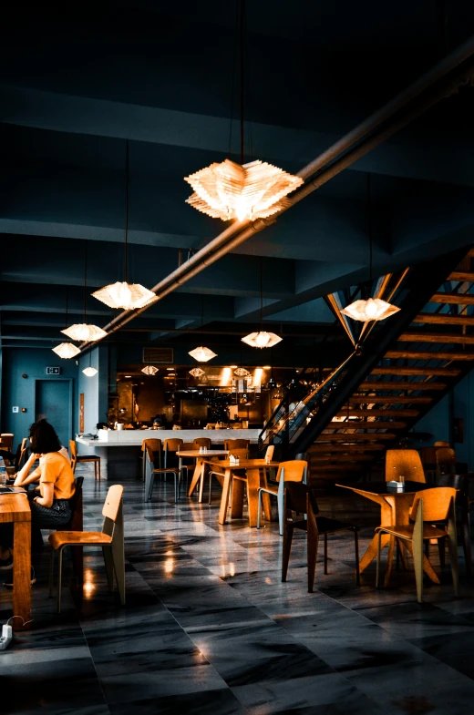 a person sitting at a table in a restaurant, by Jesper Knudsen, trending on unsplash, renaissance, industrial lighting, multiple levels, blue, inside a bar