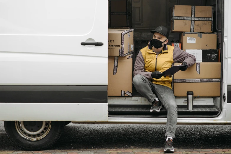 a man sitting in the open door of a van, pexels contest winner, renaissance, wearing mask, delivering packages for amazon, avatar image, yellow and charcoal leather