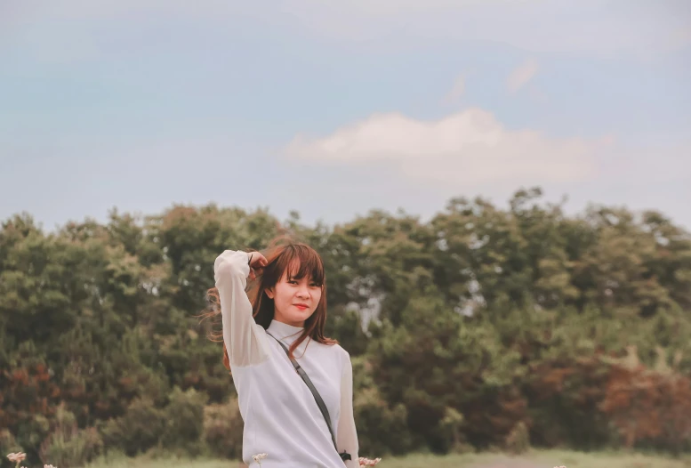 a woman posing for a picture in a field, a picture, inspired by Kim Jeong-hui, unsplash, aestheticism, wearing a white sweater, background image, japanese, 7 0 mm photo