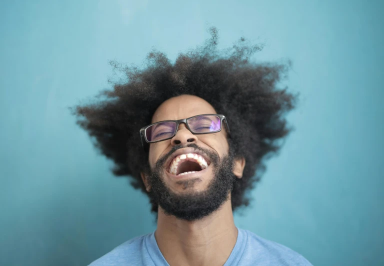 a close up of a person with a beard and glasses, by Washington Allston, pexels contest winner, funk art, laughing hysterically, afro hair, flipped out hair, man in his 30s