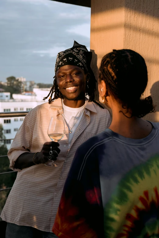 a couple of women standing next to each other, an album cover, inspired by Ras Akyem, trending on unsplash, happening, balcony scene, holding a glass of wine, dreads, still image from tv series