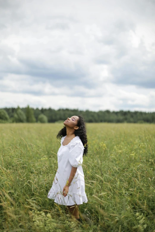 a woman standing in a field of tall grass, pexels contest winner, renaissance, praying meditating, square, african american young woman, breathing