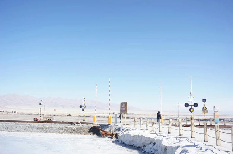 a man riding a snowboard down a snow covered slope, unsplash, land art, train station background, crossing the desert, background image, in chuquicamata