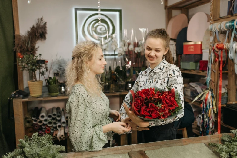 a woman standing next to a woman holding a bouquet of flowers, pexels contest winner, renaissance, flower shop scene, thumbnail, small red roses, commercial