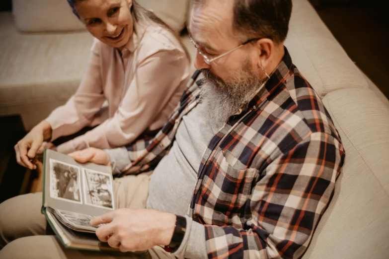 a man and a woman sitting on a couch reading a book, a photo, pexels contest winner, old man, profile image, high angle shot, casually dressed