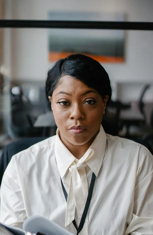 a woman in a white shirt sitting at a desk, human staring blankly ahead, riyahd cassiem, multiple stories, amanda lilleston