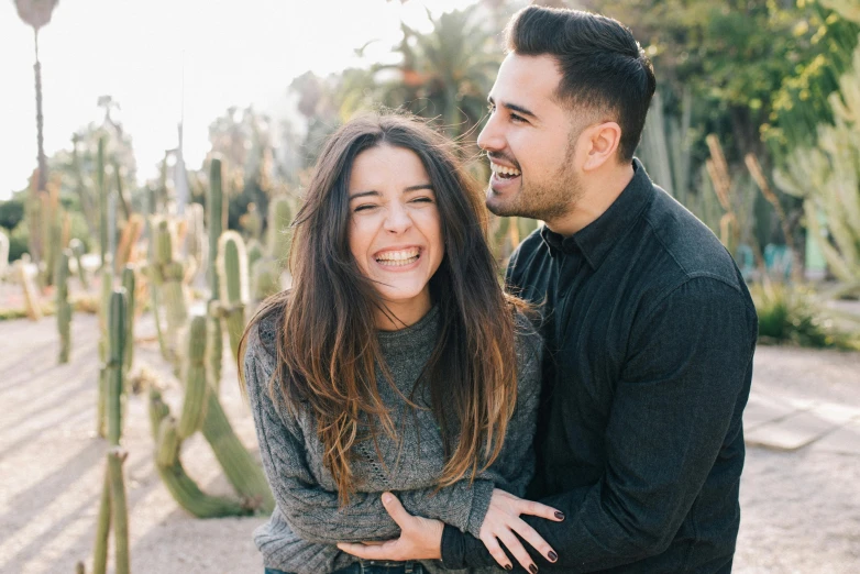 a man and woman standing next to each other in front of cacti, pexels contest winner, happening, she is laughing, chloe bennet, medium detail, spanish