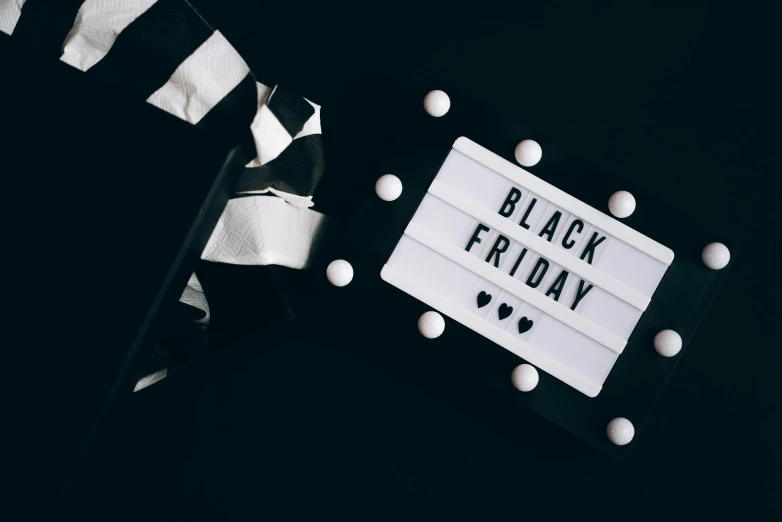 a black friday sign sitting on top of a table, pexels contest winner, hurufiyya, white and black, amanda lilleston, festive, profile image