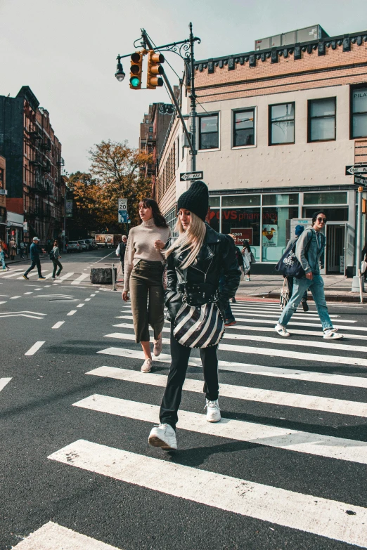 a group of people crossing a street on a crosswalk, by Nina Hamnett, trending on unsplash, woman in streetwear, new york backdrop, panoramic view of girl, blonde