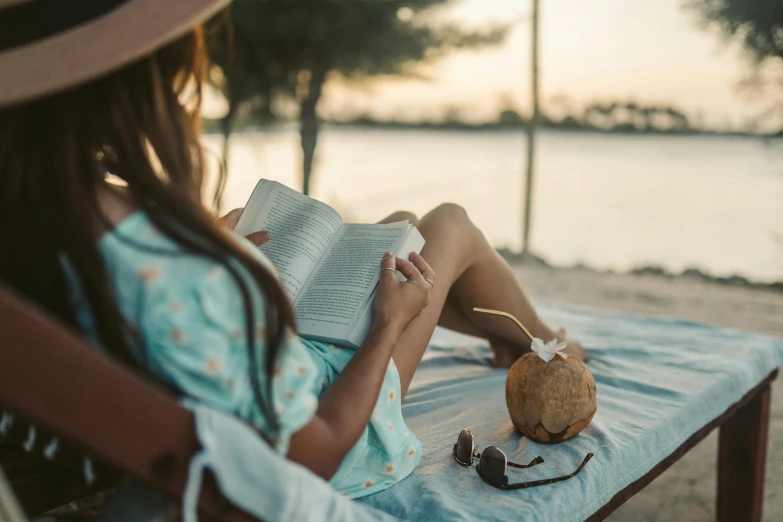 a woman sitting on a beach reading a book, pexels contest winner, coconuts, thumbnail, seasonal, ad image