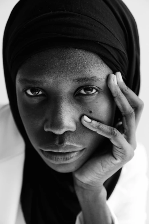 a black and white photo of a woman talking on a cell phone, by Alasdair Grant Taylor, hurufiyya, adut akech, alternate album cover, white hijab, black teenage girl