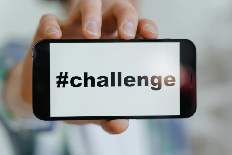 a person holding up a cell phone with the word challenge on it, pexels contest winner, hashtags, healthcare, square, innovation