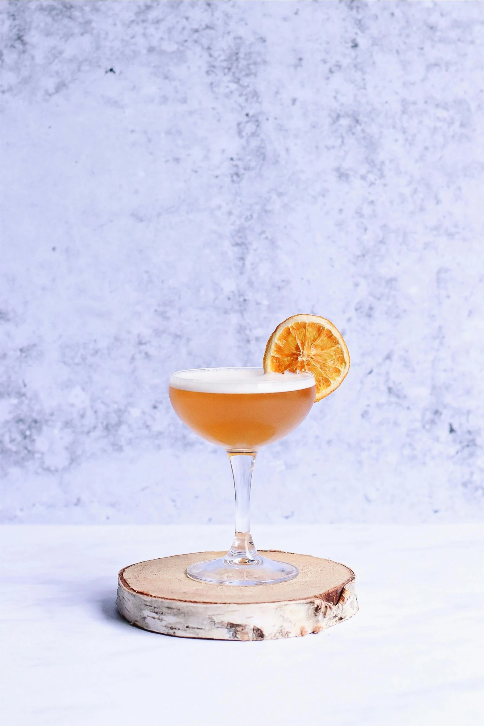 a cocktail sitting on top of a wooden coaster, inspired by Carlo Martini, orange grey white, profile image, honey, blond