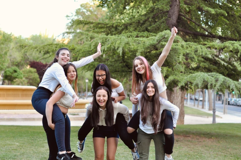 a group of women standing on top of a lush green field, unsplash, antipodeans, yearbook photo, in spain, teenage, doing a sassy pose