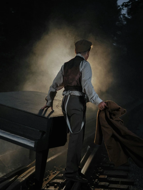 a man that is standing on a train track, an album cover, inspired by Vasily Perov, unsplash, australian tonalism, blacksmith apron, grand piano, ( ( theatrical ) ), back light