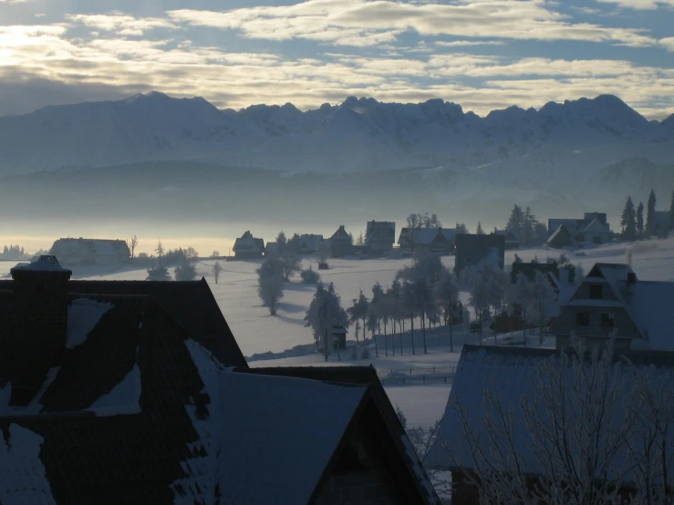 a view of a snow covered town with mountains in the background, a photo, by Daren Bader, soft morning light, avatar image, album, extremly high quality