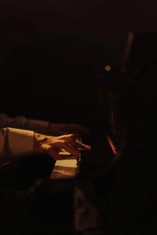 a man playing a piano in a dark room, an album cover, by Leo Michelson, pexels, todd hido, concert footage, soft light.4k, ignant