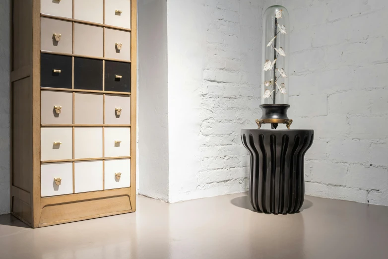 a tall wooden cabinet sitting next to a tall wooden cabinet, a marble sculpture, inspired by Harry Haenigsen, baroque, radiolaria, carbon black and antique gold, famous designer lamp, high quality product photo