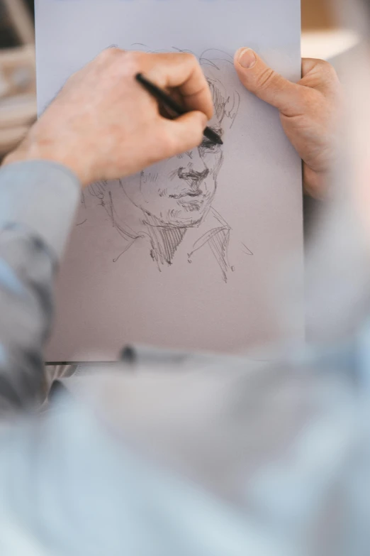 a man is drawing a picture on a piece of paper, a drawing, pexels contest winner, arbeitsrat für kunst, sharp detailed face, book portrait, 3 / 4 view portrait, ilustration