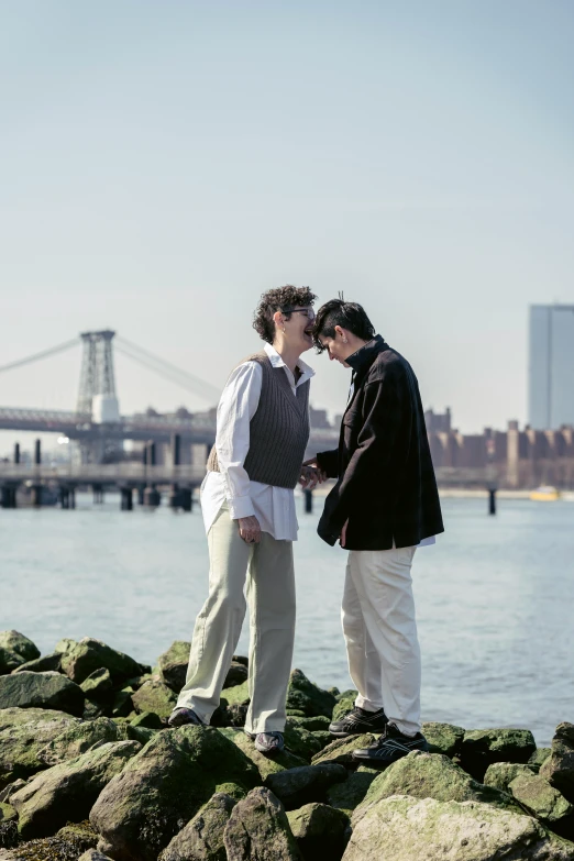 a couple of men standing next to each other on rocks, an album cover, by Nina Hamnett, romanticism, brooklyn, cityscape, ( ( theatrical ) ), longque chen