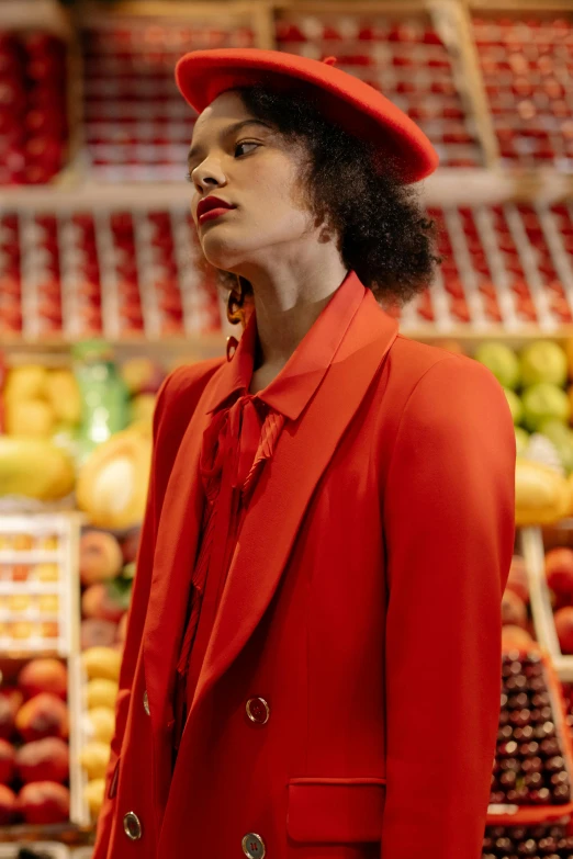 a woman in a red suit and hat standing in front of a fruit stand, off - white collection, ashteroth, red tailcoat, zoomed in
