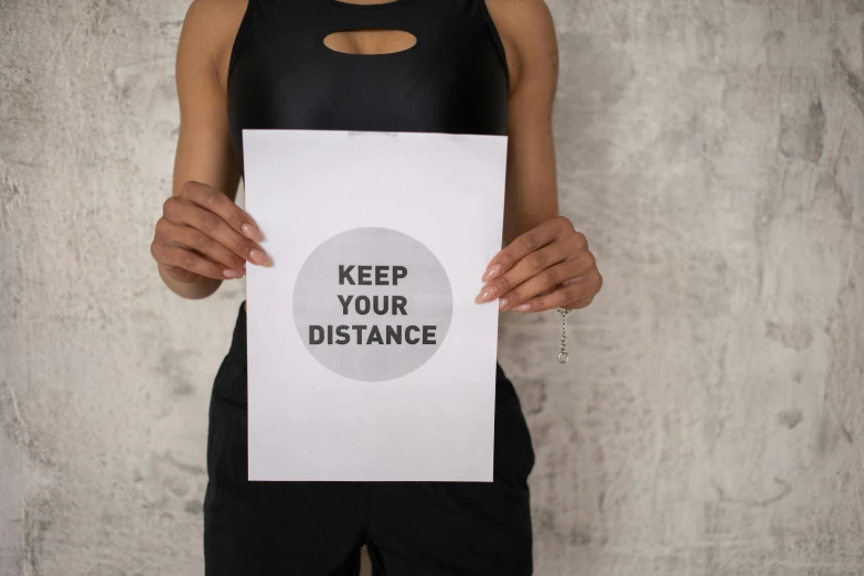 a woman holding a sign that says keep your distance, a poster, by Julia Pishtar, photographic print, workout, manuscript, elliot alderson