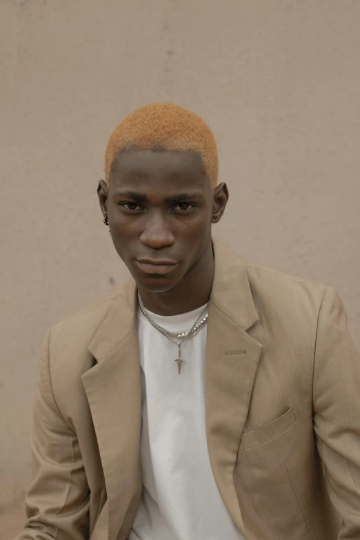 a man in a tan suit and white shirt, an album cover, inspired by Terrell James, trending on pexels, realism, dyed hair, adut akech, shady look, bleached