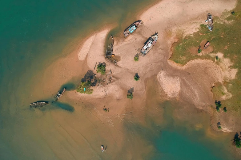 a group of boats sitting on top of a sandy beach, a digital rendering, by Daniel Lieske, pexels contest winner, land art, aerial view of an ancient land, how a river, sunken ship, laos