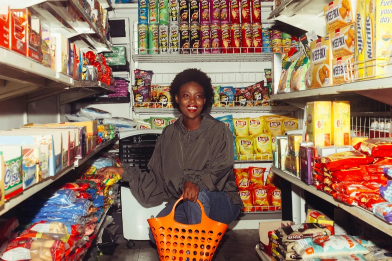 a woman holding a shopping basket in a grocery store, an album cover, by Ingrida Kadaka, pexels contest winner, dark-skinned, portra 160, delightful, full of things