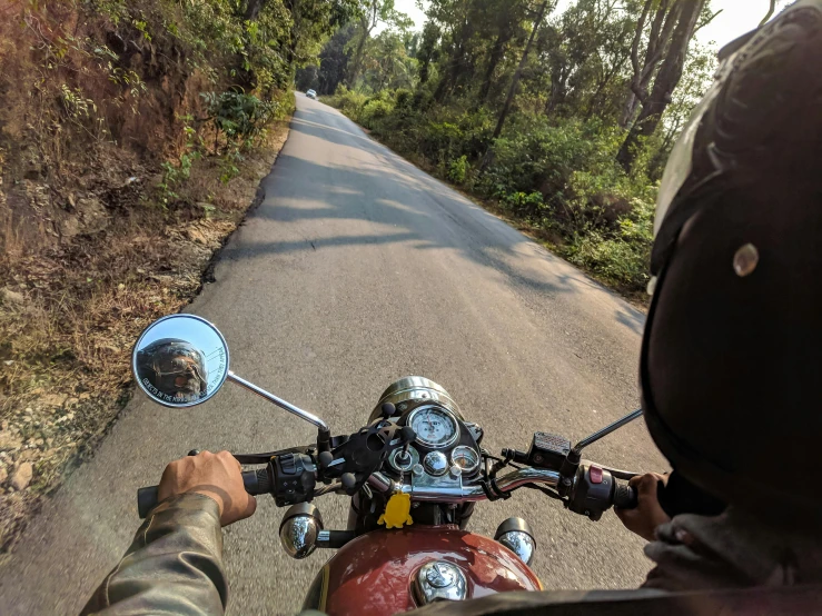 a man riding on the back of a motorcycle down a road, pexels contest winner, first - person view, avatar image, assamese aesthetic, half helmet