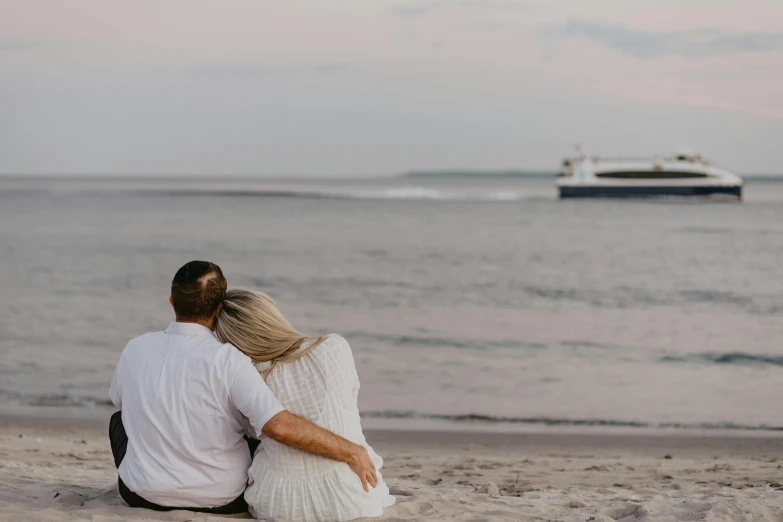 a man and a woman sitting next to each other on a beach, by Carey Morris, pexels contest winner, on a super yacht, view from the side, 2 5 6 x 2 5 6 pixels, calm evening