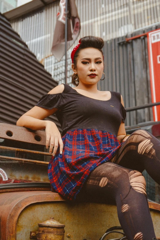 a woman sitting on top of a piece of luggage, an album cover, inspired by Eddie Mendoza, pexels contest winner, sumatraism, tartan garment, pinup, street wear, profile image