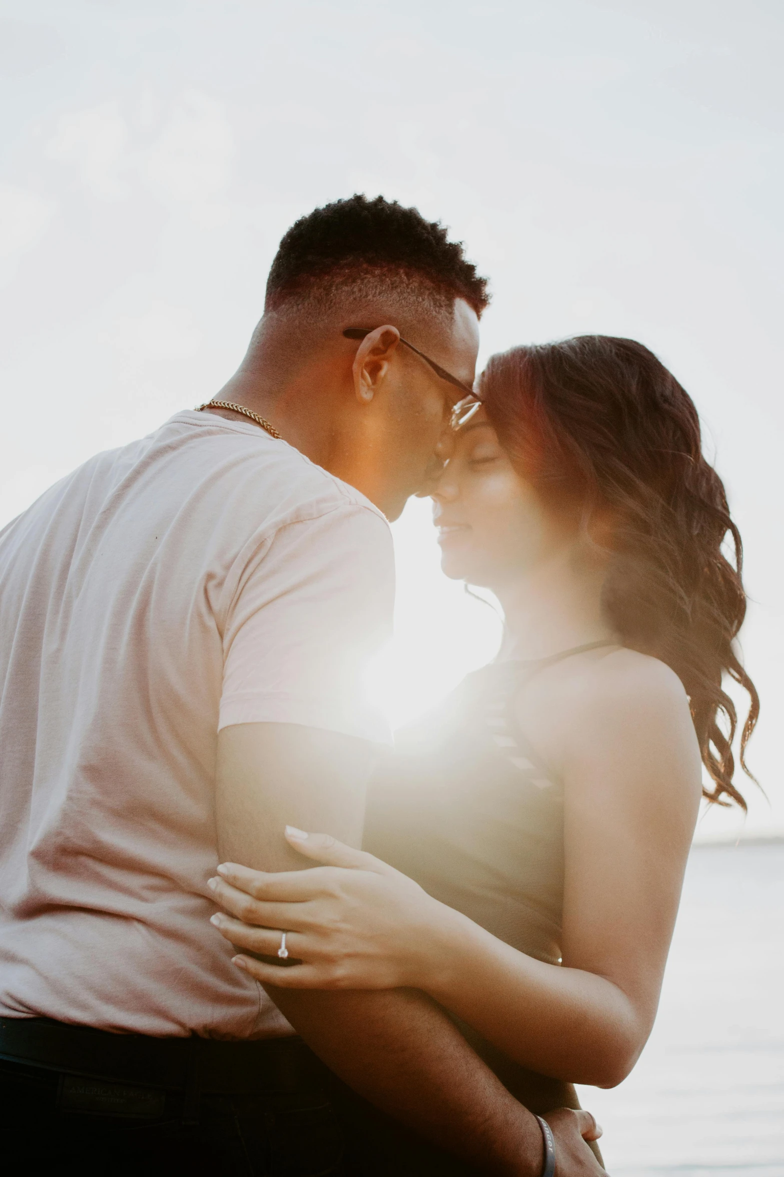 a man and woman standing next to each other on a beach, a photo, pexels contest winner, romanticism, making out, sunny lighting, hispanic, high-key