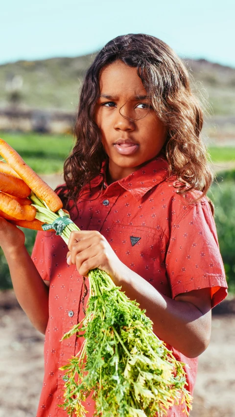 a young girl holding a bunch of carrots, by Lisa Milroy, pexels contest winner, symbolism, aboriginal australian hipster, black teenage boy, film promotional still, wearing an orange t shirt