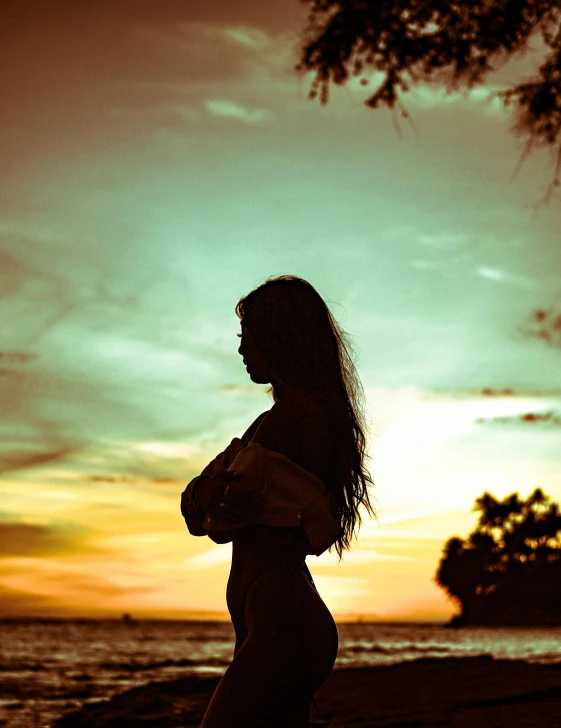 a woman standing on top of a beach next to the ocean, a picture, inspired by Elsa Bleda, unsplash, sumatraism, silhouette :7, photo of a beautiful woman, multiple stories, unhappy