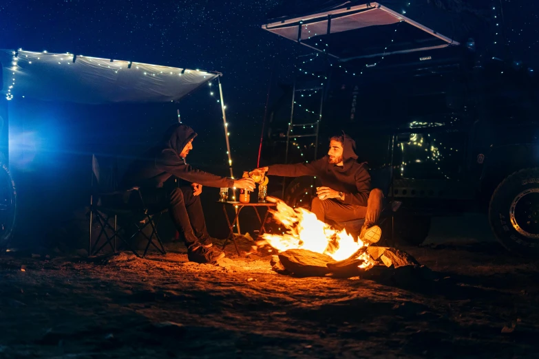 two people sitting around a campfire at night, by Lee Loughridge, unsplash contest winner, australian winter night, neon lit, glamping, fire poi