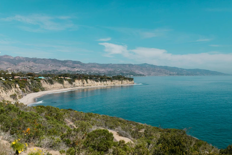 a view of the ocean from the top of a hill, a portrait, mulholland drive, turquoise water, sheer cliffs surround the scene, abcdefghijklmnopqrstuvwxyz